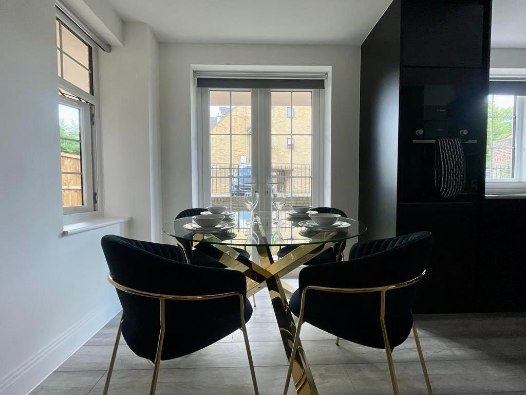 Glass dining table, black velvet chairs with gold legs