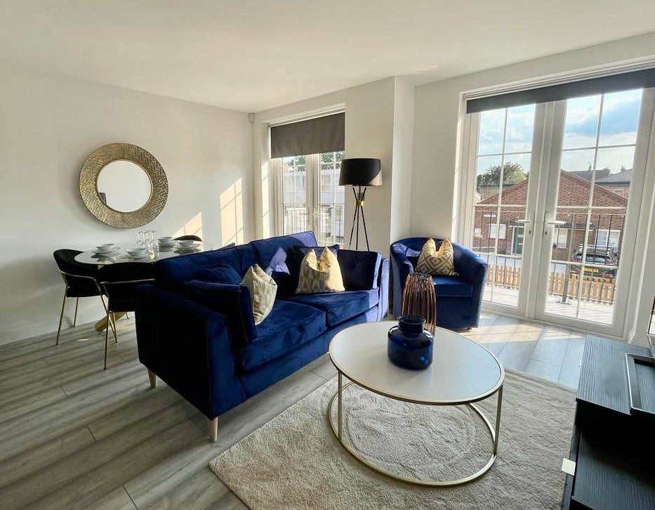 Blue velvet sofa and armchair, gold leg coffee table with marble top and oversized gold mirror
