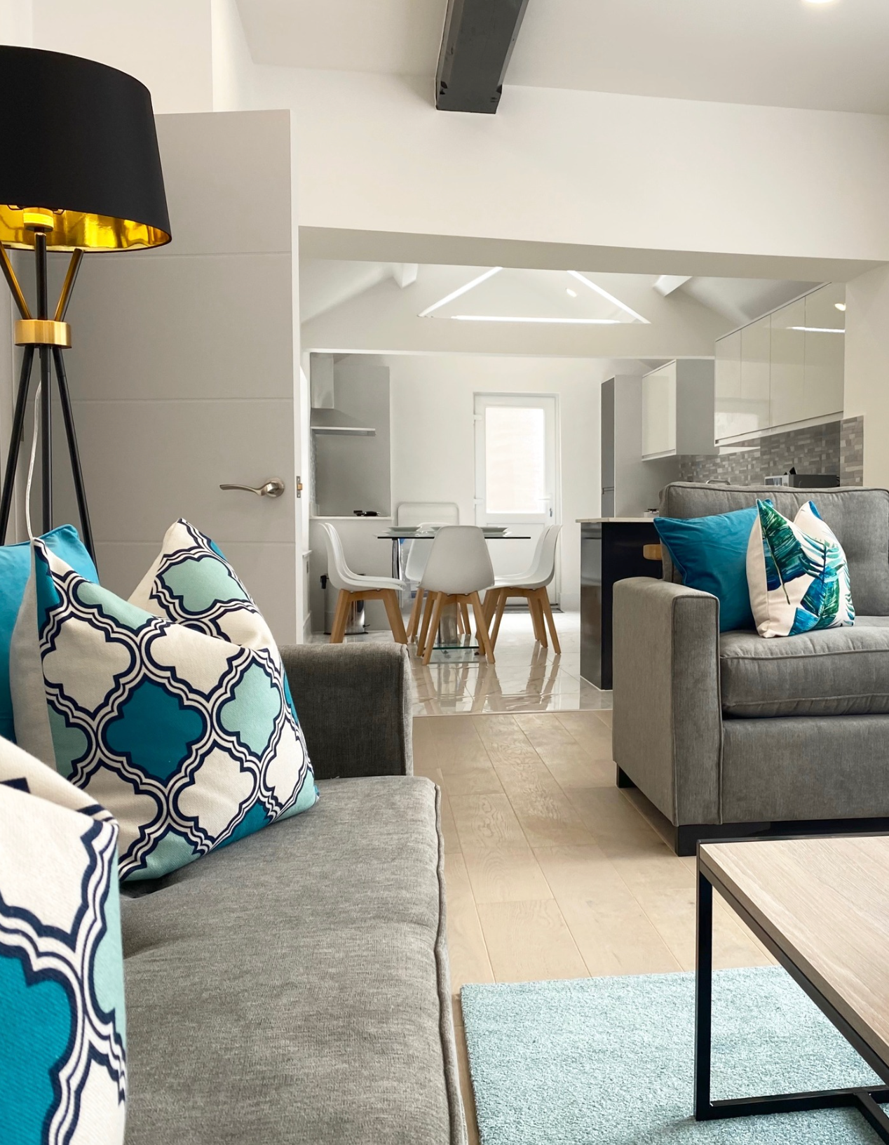 Grey sofas, blue rug, floor lamp and bright blue cushions