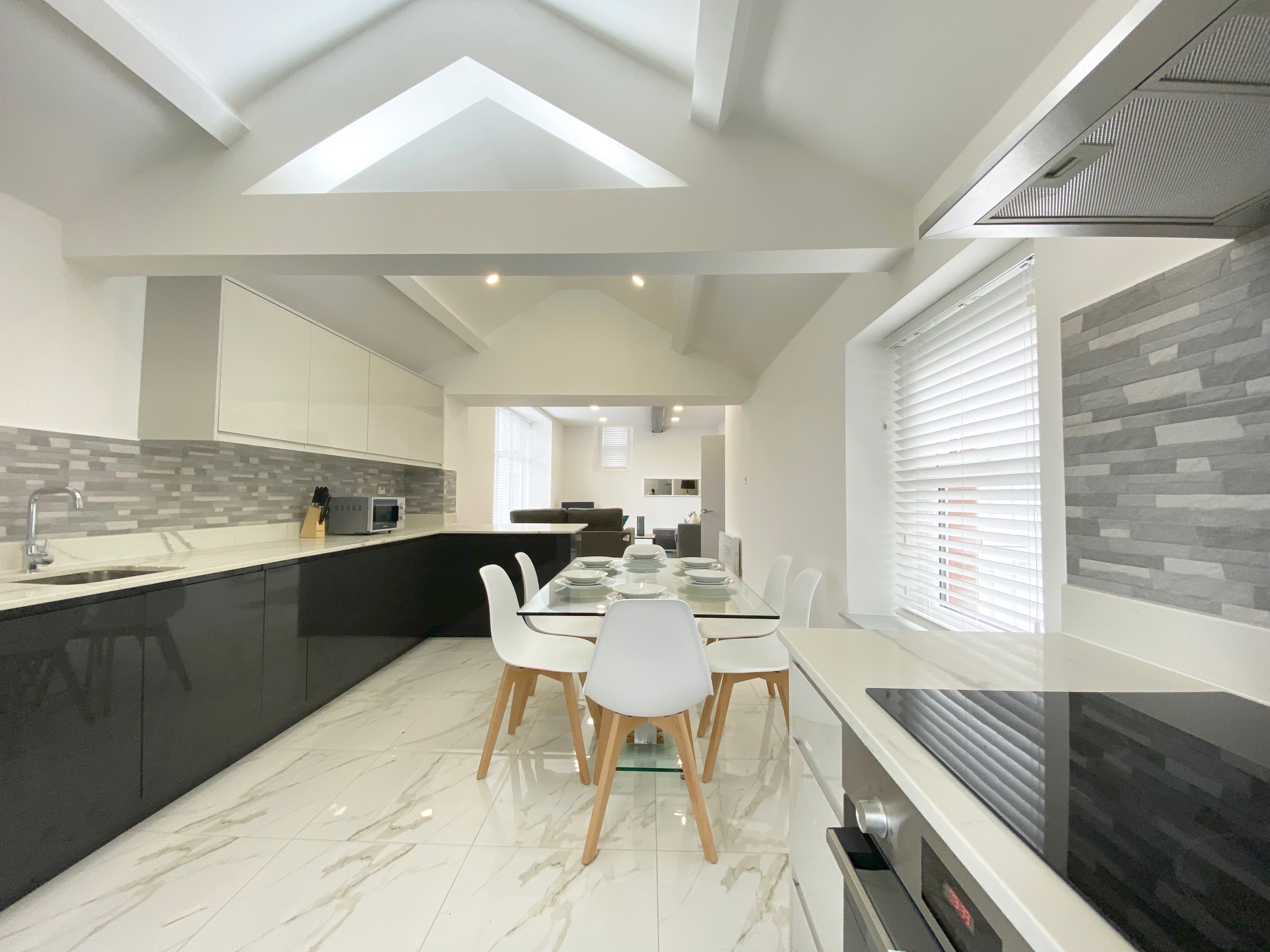 White dining table, white dining chairs, grey kitchen